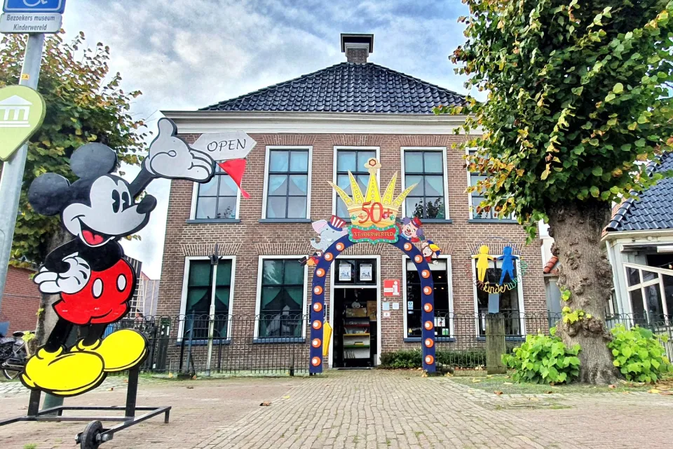 Voorgevel van het speelgoedmuseum in Roden met een groot beeld van een tekenfilmfiguur ervoor